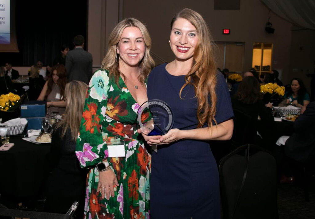 Photo of Krista and Kayla standing together, holding a PRSA Merit Award